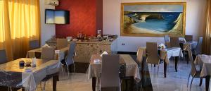 a restaurant with tables and chairs and a painting on the wall at Bed & Breakfast Isola Bella Lampedusa in Lampedusa