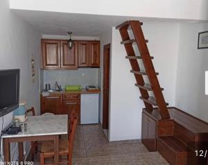 a kitchen with a staircase leading into a kitchen with a table at Asvestoti blue ciel light 2 in Pera Gyalos