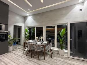 a dining room with a table and some plants at Radiance Holiday Resort Muscat in Seeb