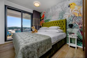 a bedroom with a large bed with a cat sitting on it at Apartments Penthouse lux XYZ in Rogoznica