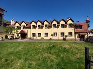 a large building with a grass field in front of it at Wilcza łapa in Pieszyce