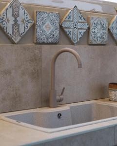un lavello da cucina con un mucchio di piastrelle sul muro di Nausicaa Guesthouse a Marsala Altre 37 foto