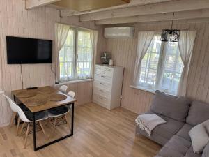 a living room with a table and a couch at Melluži tiny house 35m2 in Jūrmala