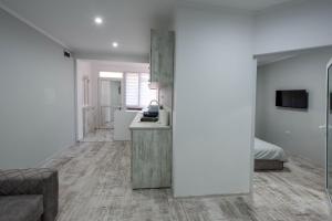 una cucina e un soggiorno con pareti bianche e divano di Secret Guest House a Plovdiv