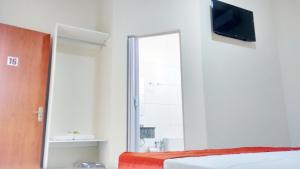 a bedroom with a bed and a mirror and a television at Casas Novas Hotel in Penápolis