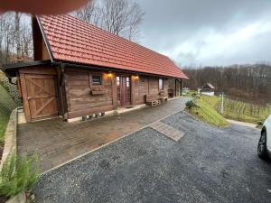 a log cabin with a red roof on a driveway at Kuća za odmor Foresta in Ladvenjak