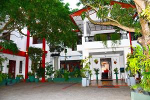 a white building with plants in front of it at Thilaka City Hotel in Anuradhapura