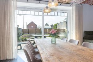a dining room table with a vase of flowers on it at Huyze Basco in Poperinge