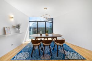 a dining room with a table and chairs on a rug at Pedrinhas Village in Apúlia