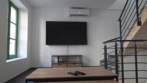 a living room with a flat screen tv on a wall at Maison cosy in Saint-Gilles