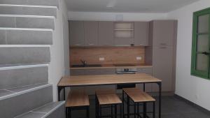 a kitchen with a wooden table and stools at Maison cosy in Saint-Gilles