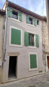 a building with green shutters on the side of it at Maison cosy in Saint-Gilles