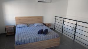 a bedroom with a bed with two blue shoes on it at Maison cosy in Saint-Gilles