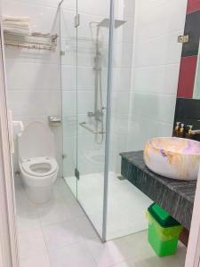 a bathroom with a toilet and a glass shower at khach san Đà Lạt NMC - Cách Chợ Đêm Chỉ 20mét in Da Lat