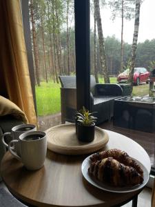 a table with a cup of coffee and a plate of food at Leśne Domki in Życiny +65 photos