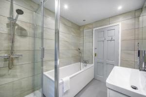 a bathroom with a tub and a shower and a sink at 51VL For your Stylish and Relaxed Stay with Free Parking and Free WiFi in Kirkstall +38 photos