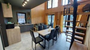a kitchen and dining room with a table and chairs at Leśne Domki in Życiny