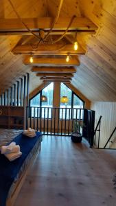 a large room with a bed in a wooden building at Leśne Domki in Życiny