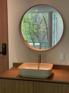 a bathroom sink with a round mirror above it at MAPLE MANSION Hongdae in Seoul +108 photos