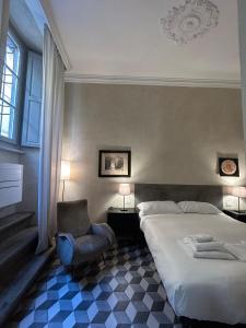 ein Schlafzimmer mit einem Bett und einem Stuhl in der Unterkunft Palazzo Mormorai in Florenz