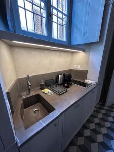 eine Küchentheke mit Spüle und blauen Schränken in der Unterkunft Palazzo Mormorai in Florenz + 68 Fotos