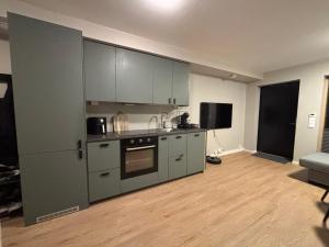 a kitchen with stainless steel appliances and a living room at 2-roms med parkering i Bodø in Bodø