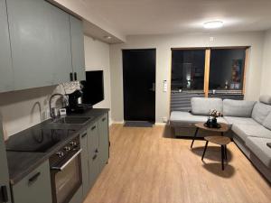 a kitchen and living room with a couch and a table at 2-roms med parkering i Bodø in Bodø