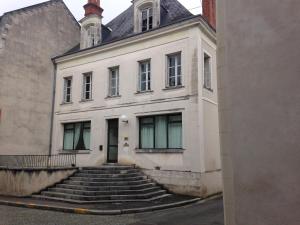 ein weißes Gebäude mit einer Treppe davor in der Unterkunft Maison du chatelain in Saint-Aignan