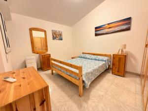 a bedroom with a bed and a table and a mirror at iDream on the sea in Punta Braccetto