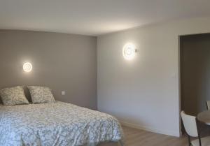 - une chambre avec un lit et deux lumières sur le mur dans l'établissement Au bord du Tarn, à Vabre