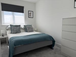 une chambre blanche avec un lit avec une fenêtre dans l'établissement Strikingly Stylish Exeter Retreat - Modern 3-Bed, à Exeter
