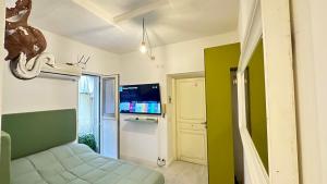 Una habitación con una cama y un televisor en una habitación. en Tiny Elephant Mini suite in Rome, en Roma