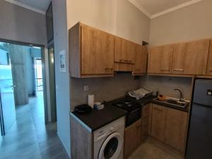 a kitchen with wooden cabinets and a washing machine at The Nest Apartment in Agioi Theodoroi +20 photos