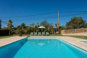 a swimming pool with two chairs and an umbrella at Villa Can Blai in Santa Eularia des Riu