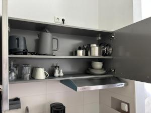 a kitchen with pots and pans on a shelf at Boardinghouse Gruber in Kranzberg +3 photos