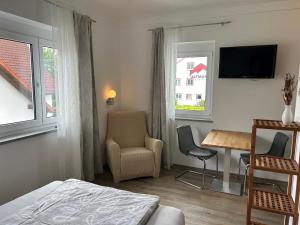 a hotel room with a bed and a table and chairs at Boardinghouse Gruber in Kranzberg