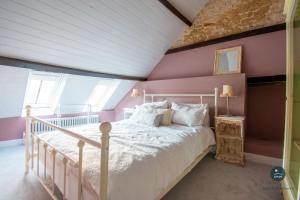 a bedroom with a white bed and pink walls at Stable Cottage at Poxwell Manor in Poxwell