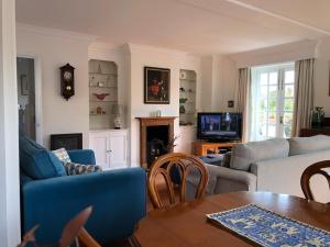 a living room with a blue couch and a table at Kingfisher House - Sandwich in Sandwich