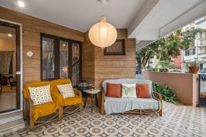 a porch with two chairs and a table and a lamp at Gaia Homes in Bengaluru