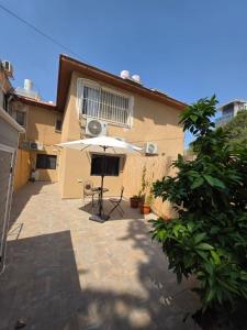 a patio with a table and an umbrella at Benemanuel Oasis in Beer Sheva