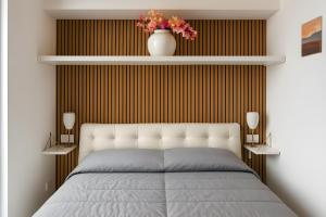 a bedroom with a bed and a vase with flowers at Hostel Brikette in Positano