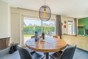 a dining room with a wooden table and chairs at Hoogelandt 90A in De Koog
