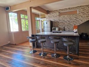 a kitchen with a counter with bar stools in it at En-suite Rooms in shared appartment in Quatre Bornes