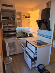 a kitchen with a stove and a counter top at Moderne Wohnung mit Sonnenuntergang über dem Meer in Heiligenhafen