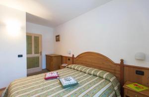 a bedroom with a bed with two books on it at Casa Clelia in Pellizzano