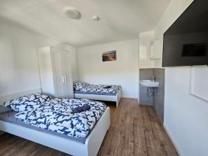 een slaapkamer met 2 bedden en een wastafel. bij SIM01 Renovierte Monteurs- und Ferienwohnung in Simmerath in Simmerath