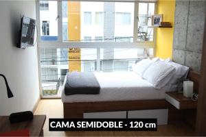 马尼萨莱斯Ulivin Coliving的一间卧室，里面有一张床和一扇大窗户。