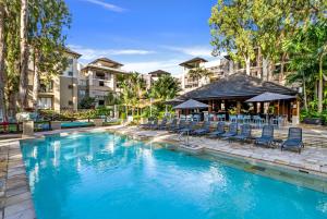 a swimming pool with chairs and a bar at Vista Verde - A Temple Resort Family Treasure in Palm Cove