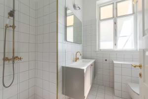 a white bathroom with a sink and a shower at Centrally Located 3 Bedroom Apartment in Copenhagen