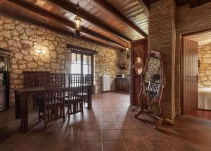 comedor con mesa, sillas y pared de piedra en Armos Stone Villa - Private Pool & Sea Views, by ZanteWize, en Skinária 49 fotos más